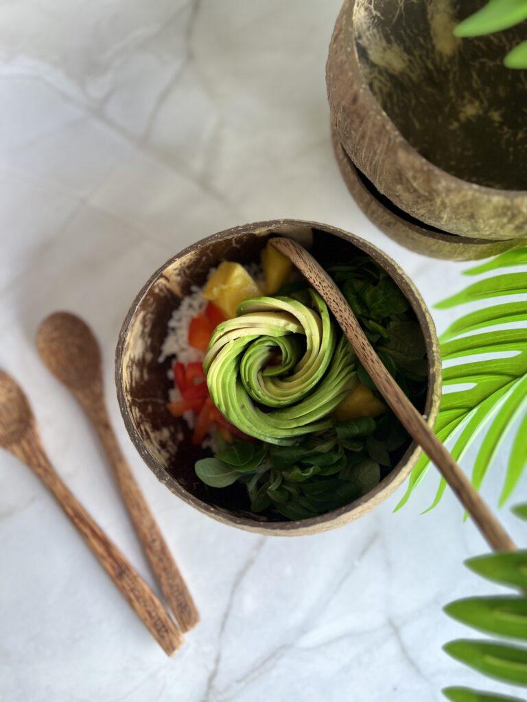 Bunte Schüssel mit gesundem Salat und Avocado auf Marmortisch